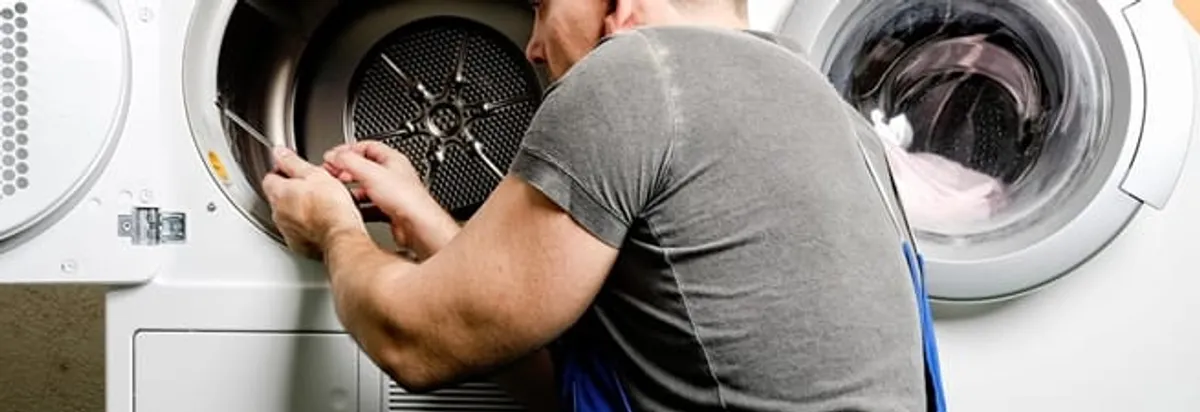 Dryer repair technician fixing a clothes dryer drum in Arvada, CO