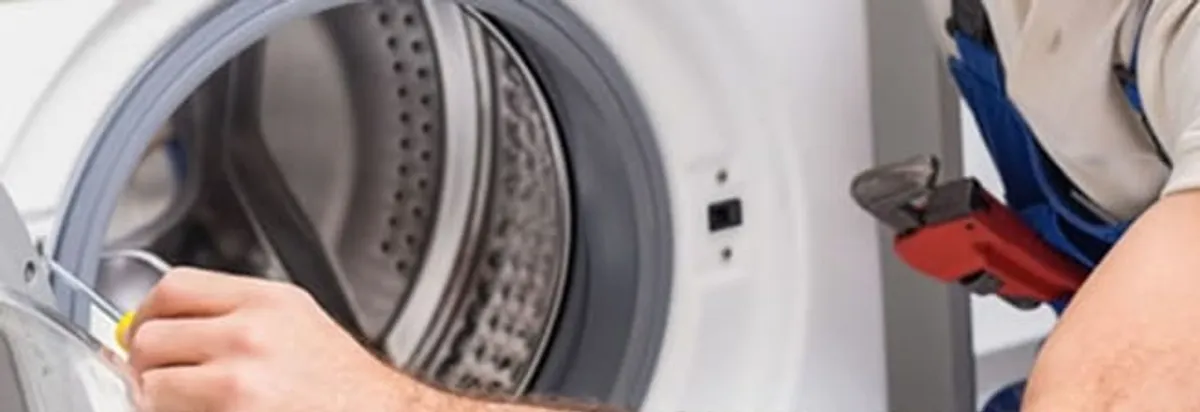 Appliance technician repairing a clothes dryer drum and internal parts in Arvada, CO