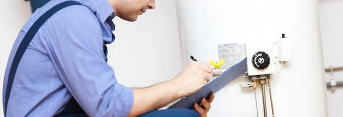 Water heater repair technician inspecting the unit and recording service notes in Arvada, CO